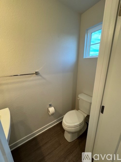 A white toilet sits in a bathroom next to a white sink.