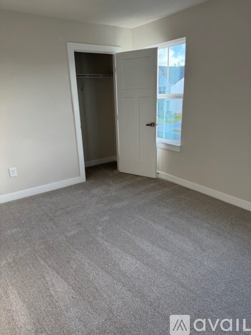 A room with a grey carpet and a white door.