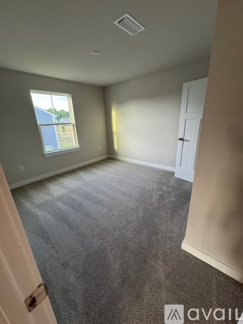 A room with a carpeted floor and a window.