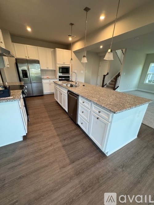 A kitchen with white cabinets and a granite countertop.