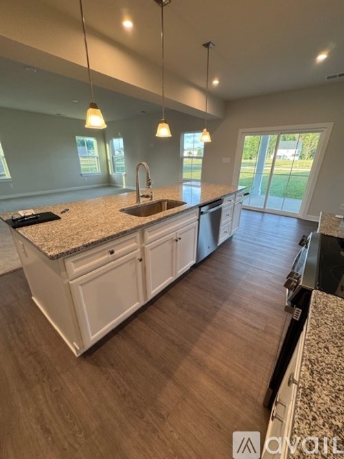 A kitchen with white cabinets and a granite countertop.