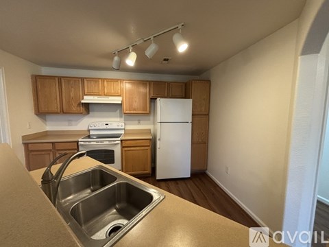 A kitchen with wooden cabinets and a white refrigerator.