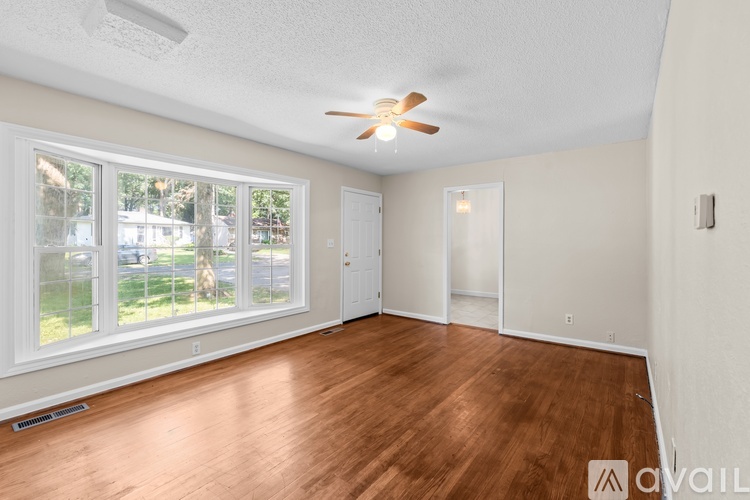 A room with a ceiling fan and wooden flooring.
