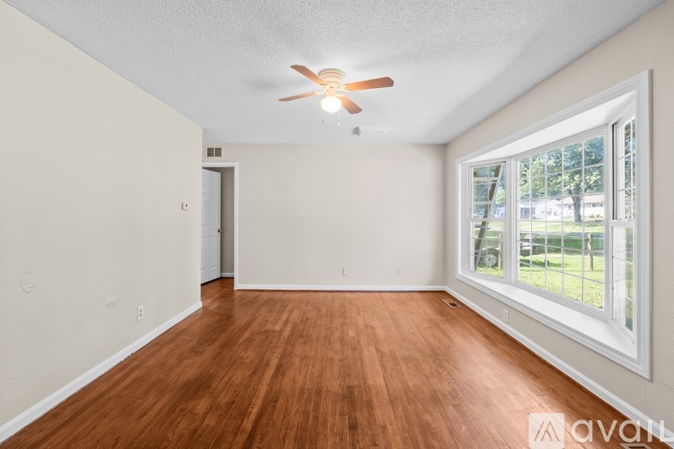 A room with wooden floors and a ceiling fan.