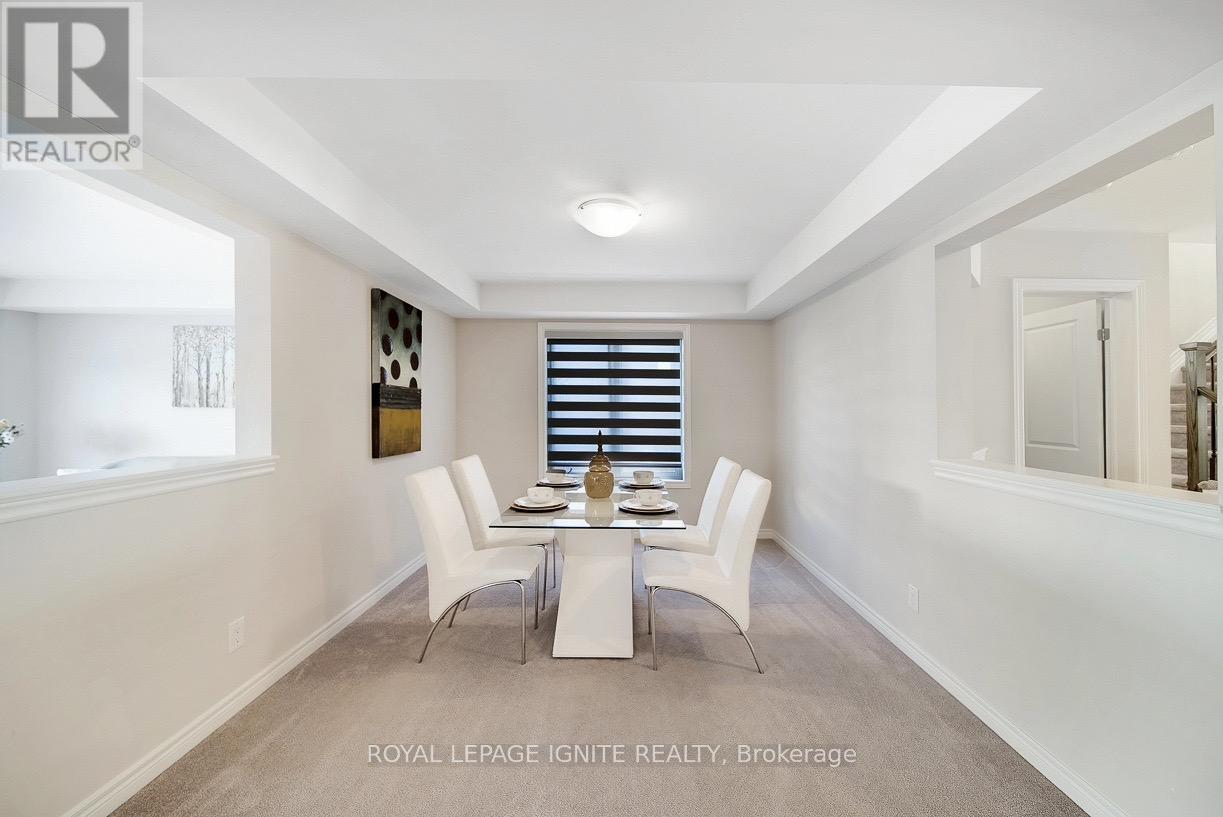 A dining room with white chairs and a table.