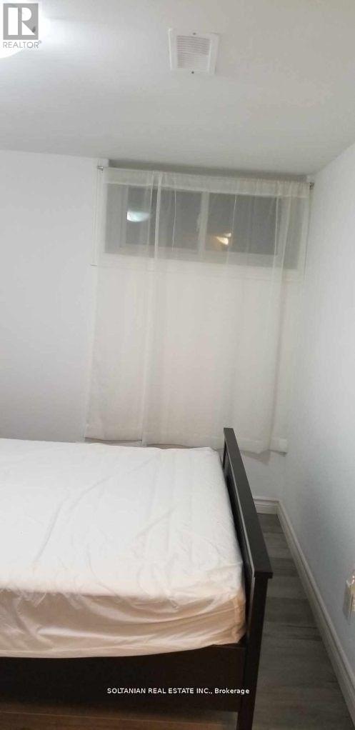 A bedroom with a bed and a window with curtains.