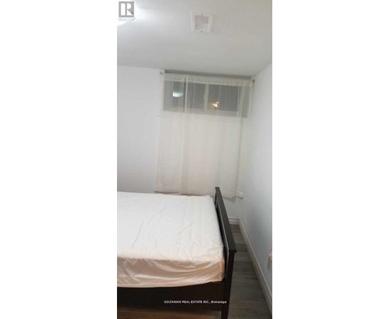 A bedroom with a bed and a window with curtains.