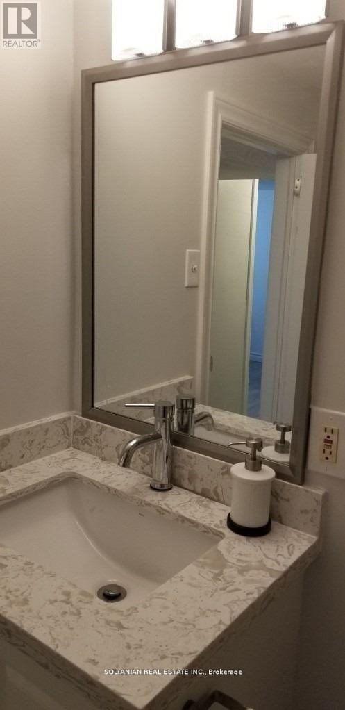 A bathroom with a marble sink and a large mirror.