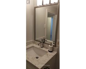 A bathroom with a marble sink and a large mirror.