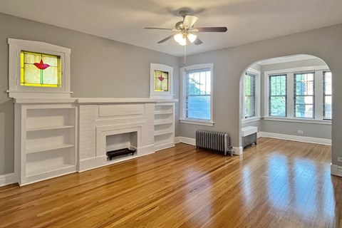 A room with a fireplace and a ceiling fan.