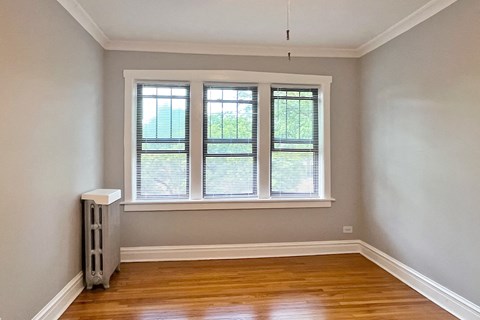 A room with a window and a radiator on the floor.