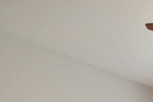 264 an empty room with a radiator and a window and a ceiling fan