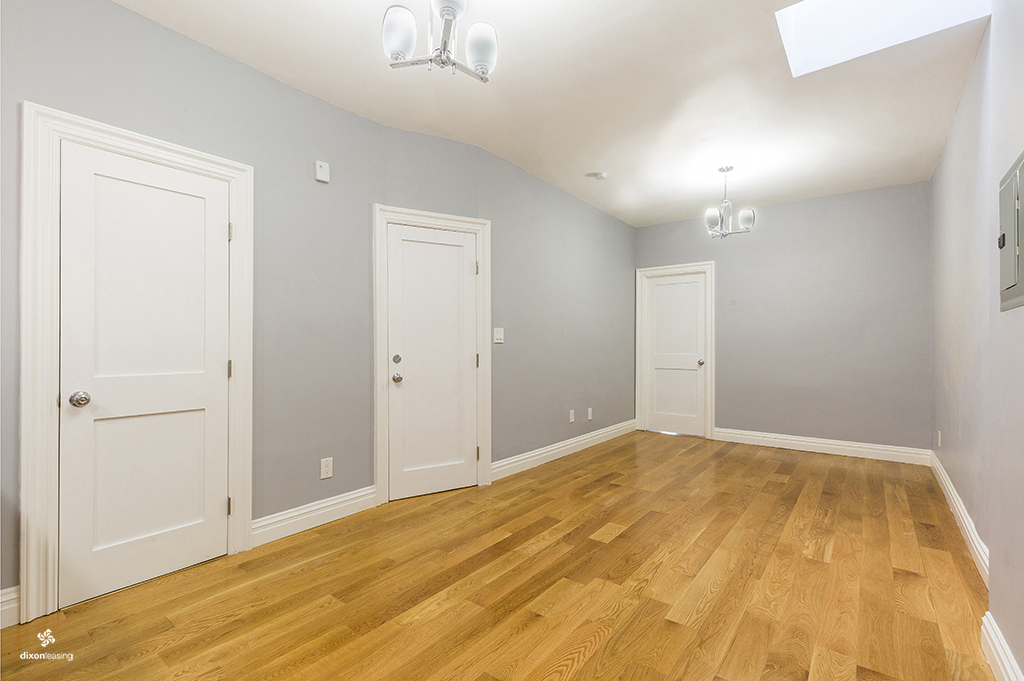 an empty living room with wood floors and white doors