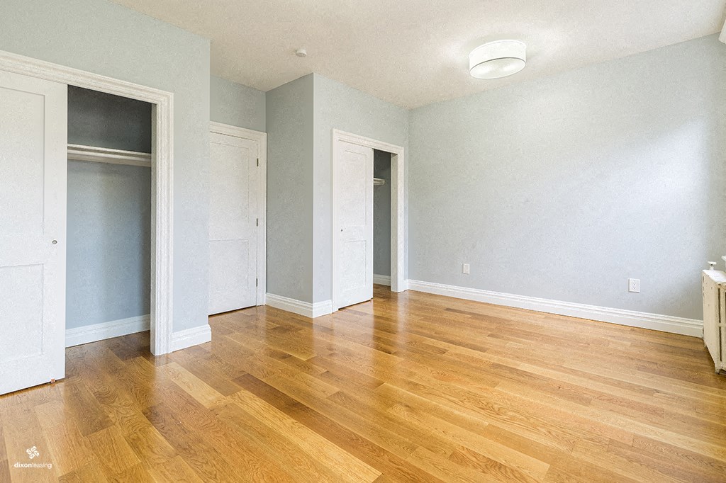 an empty living room with wood floors and blue walls
