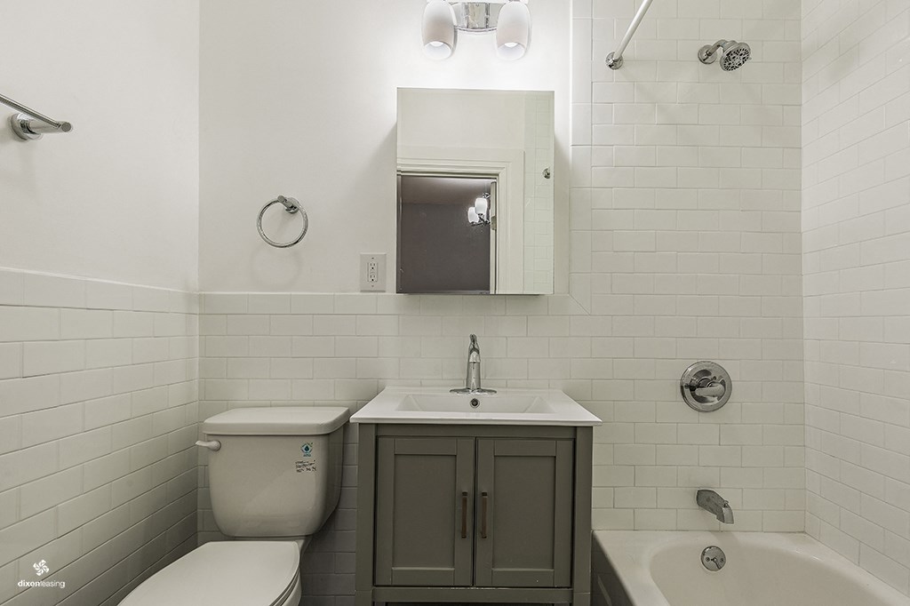 a bathroom with a toilet sink and mirror and a tub