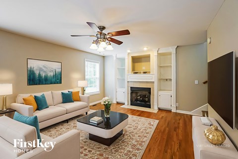 A living room with a fireplace and a painting on the wall.