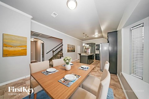 A dining room with a wooden table set for two.