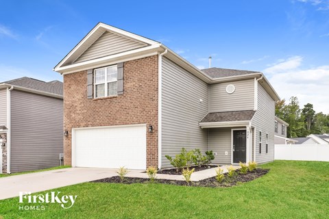 A house with a garage and a driveway in front of it.