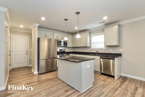 A kitchen with a stainless steel refrigerator and a wooden island.