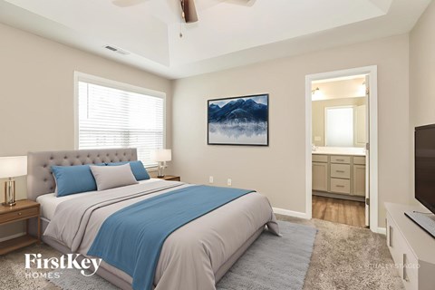 A bedroom with a large bed and a painting on the wall.