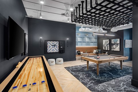 A room with a pool table and a shelf with bottles.