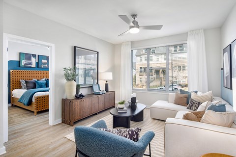 A living room with a blue chair and a white couch.