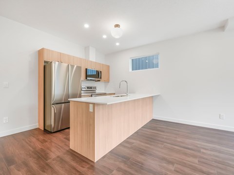 A kitchen with a wooden counter and a stainless steel refrigerator.