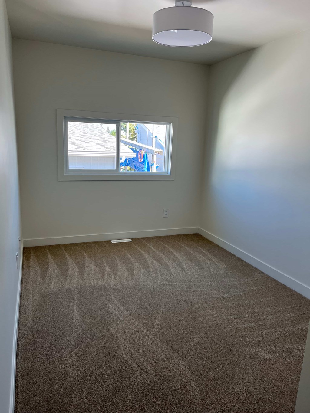A room with a carpeted floor and a window.