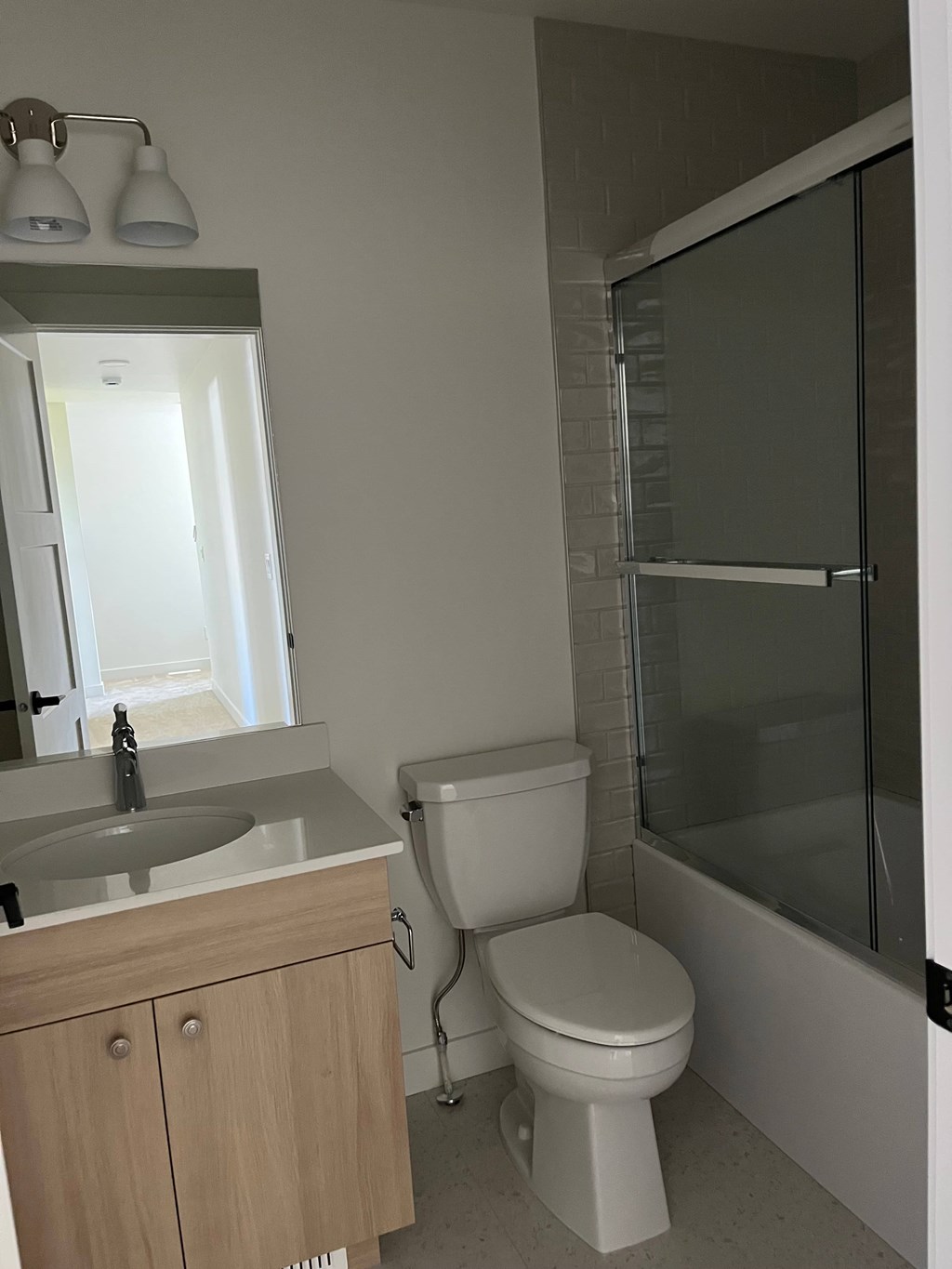 A bathroom with a toilet, sink, and shower.