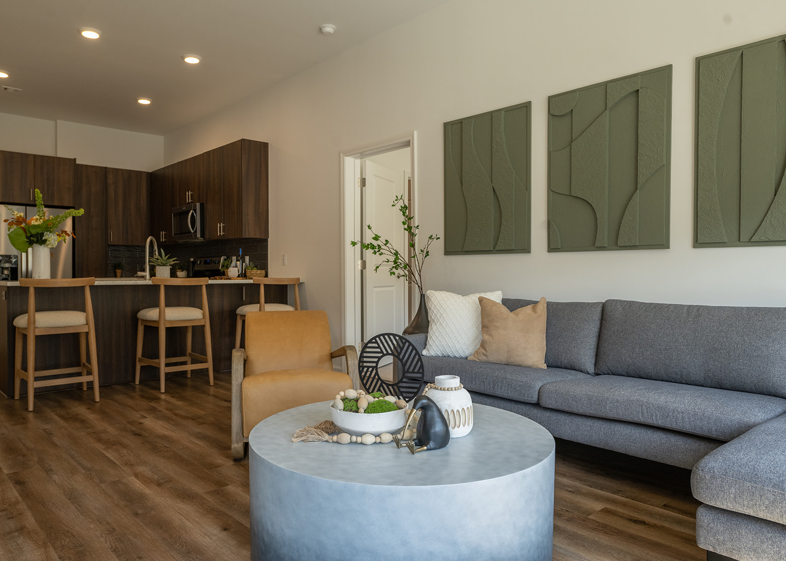 A modern living room with a grey couch and a grey coffee table.