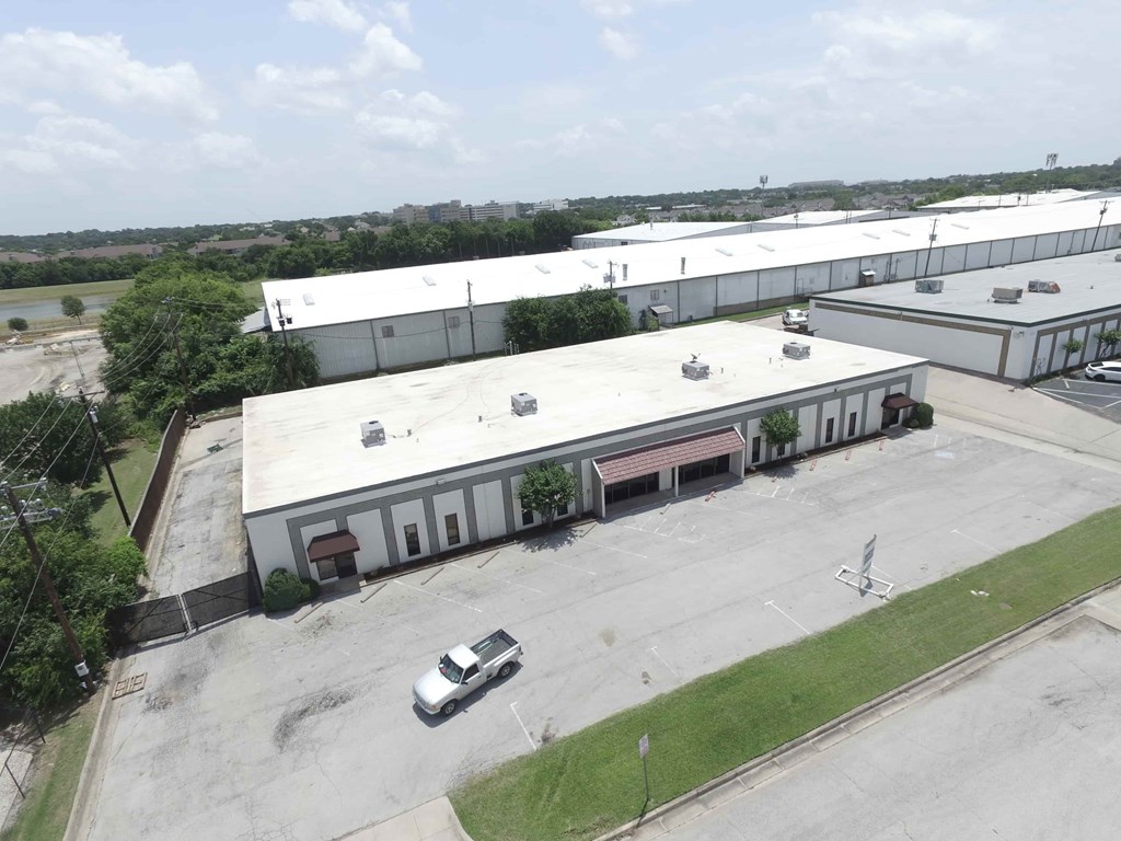A white building with a parking lot in front.