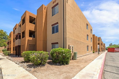 A large building with a red container in front of it.