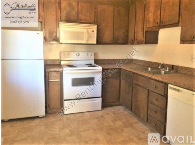 A kitchen with a white refrigerator, white oven, and wooden cabinets.