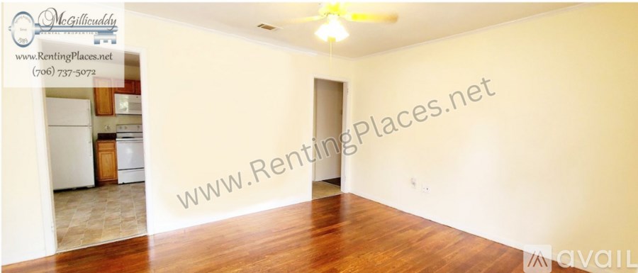 A room with wooden floors and white walls is available for rent.