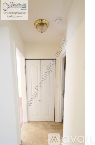 A hallway with a door and a light fixture.