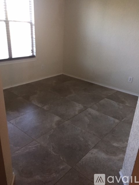 A room with a tiled floor and a window.