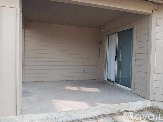 A small covered patio area with a sliding glass door.