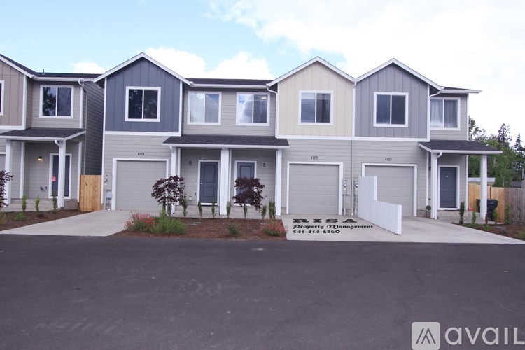 A row of houses with the first one on the left having a brown door and the second one having a white door.