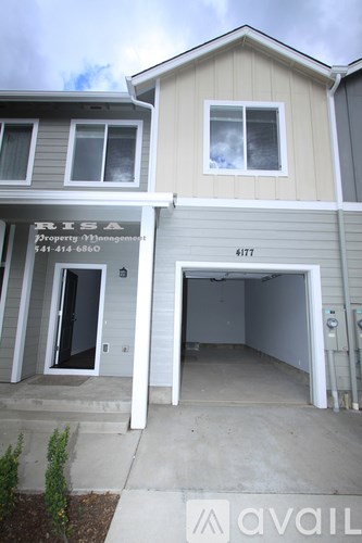 A two story house with a garage on the bottom floor.