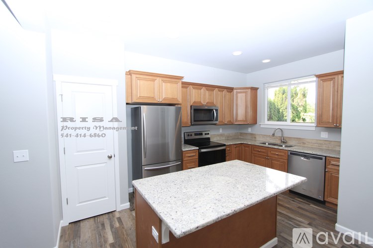 A kitchen with wooden cabinets and a marble countertop.