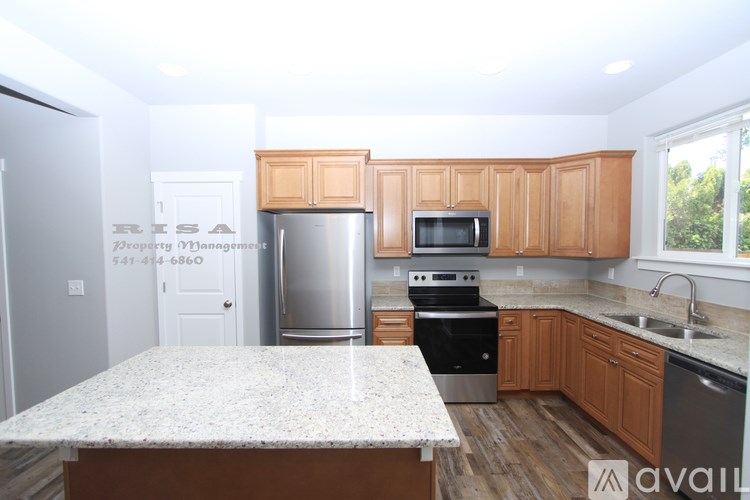 A kitchen with a granite countertop and wooden cabinets.