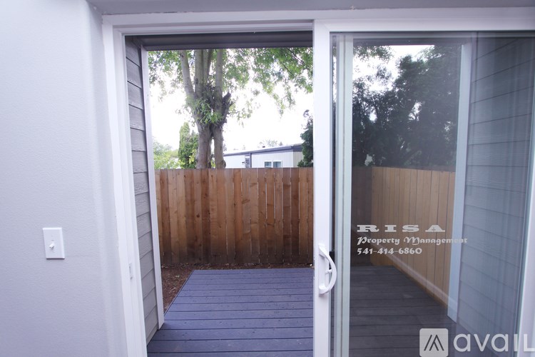 A doorway leading to a deck with a risa property management sign on the glass.