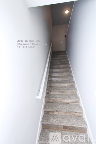 A staircase with a textured carpeted runner and wooden steps.
