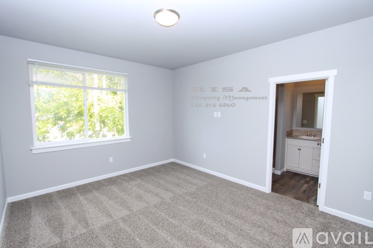 A room with a window and a carpeted floor.