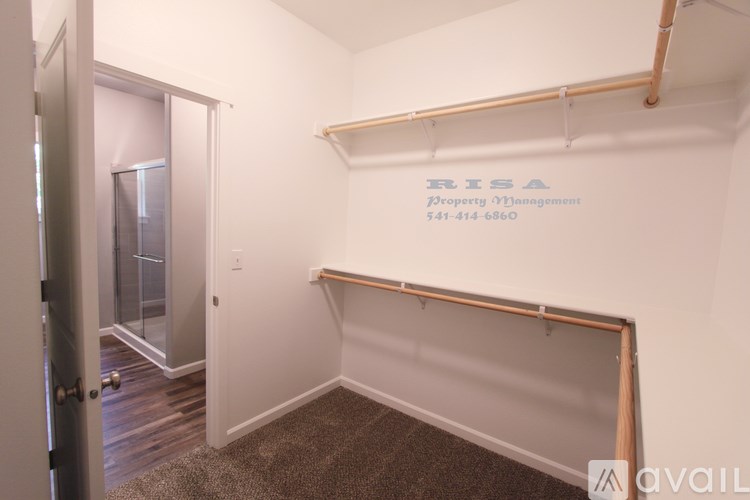 A room with a white wall and a shelf with a sign that says "RISA Property Management" and a phone number.