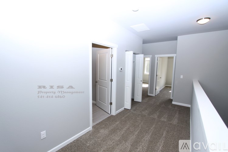A hallway with a door on the left and a carpeted floor.
