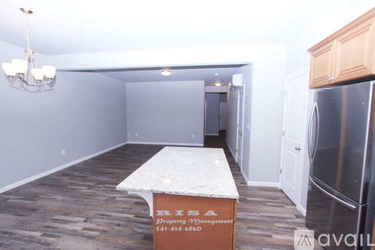 A kitchen with a fridge and a table with a sign on it.