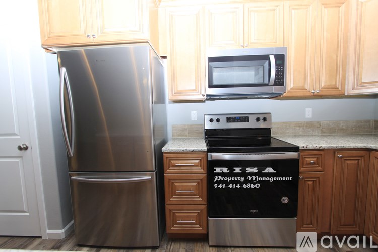 A stainless steel refrigerator and microwave in a kitchen.