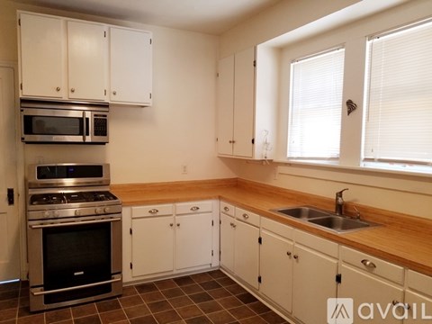 A kitchen with white cabinets and a stainless steel oven.