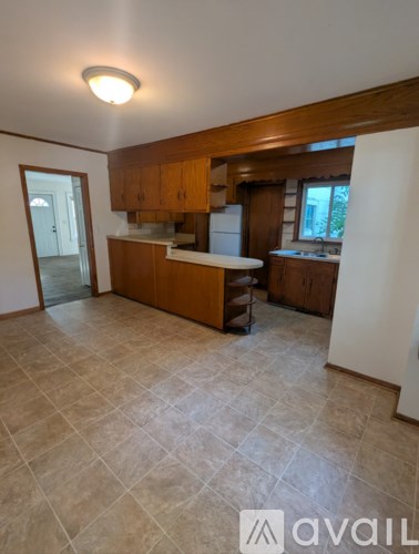 A kitchen with wooden cabinets and a tiled floor.
